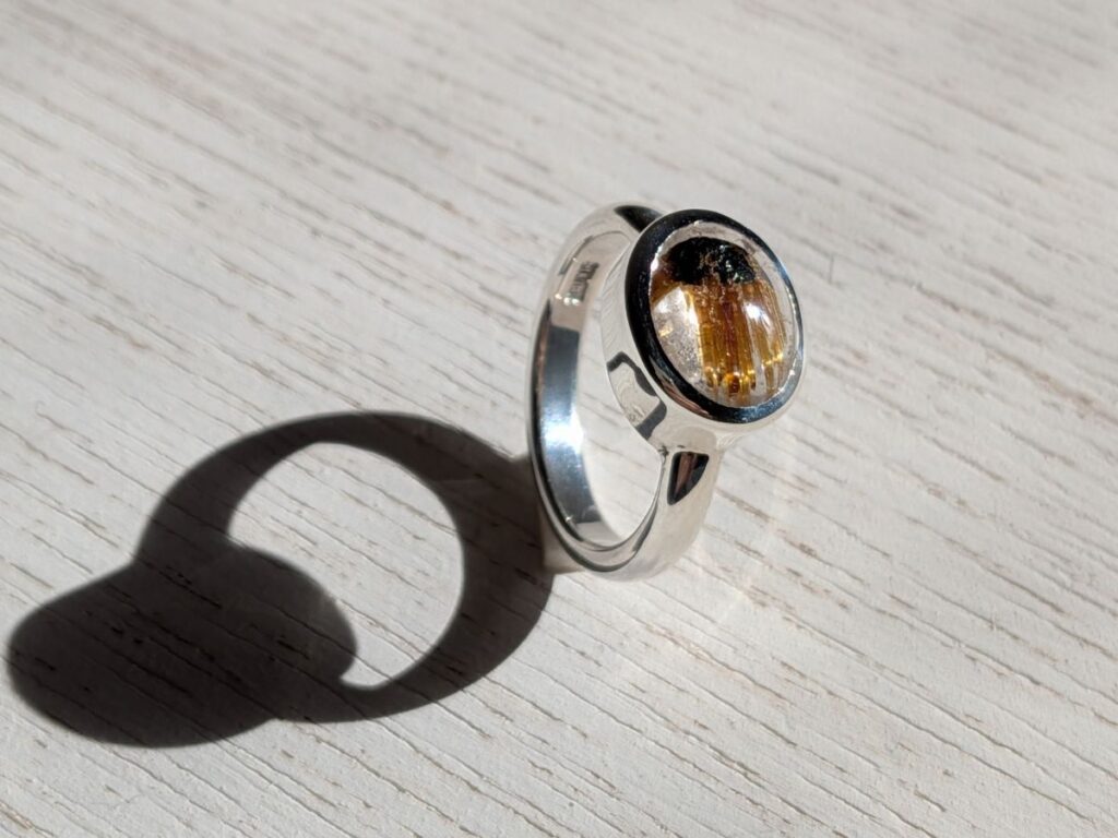 黄金色のルチルが放射状に伸びる「太陽放射ルチル」のヘマタイト・ルチルクオーツ