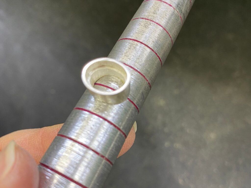 指輪のサイズ棒に乗せてカーブの形を合わせていく