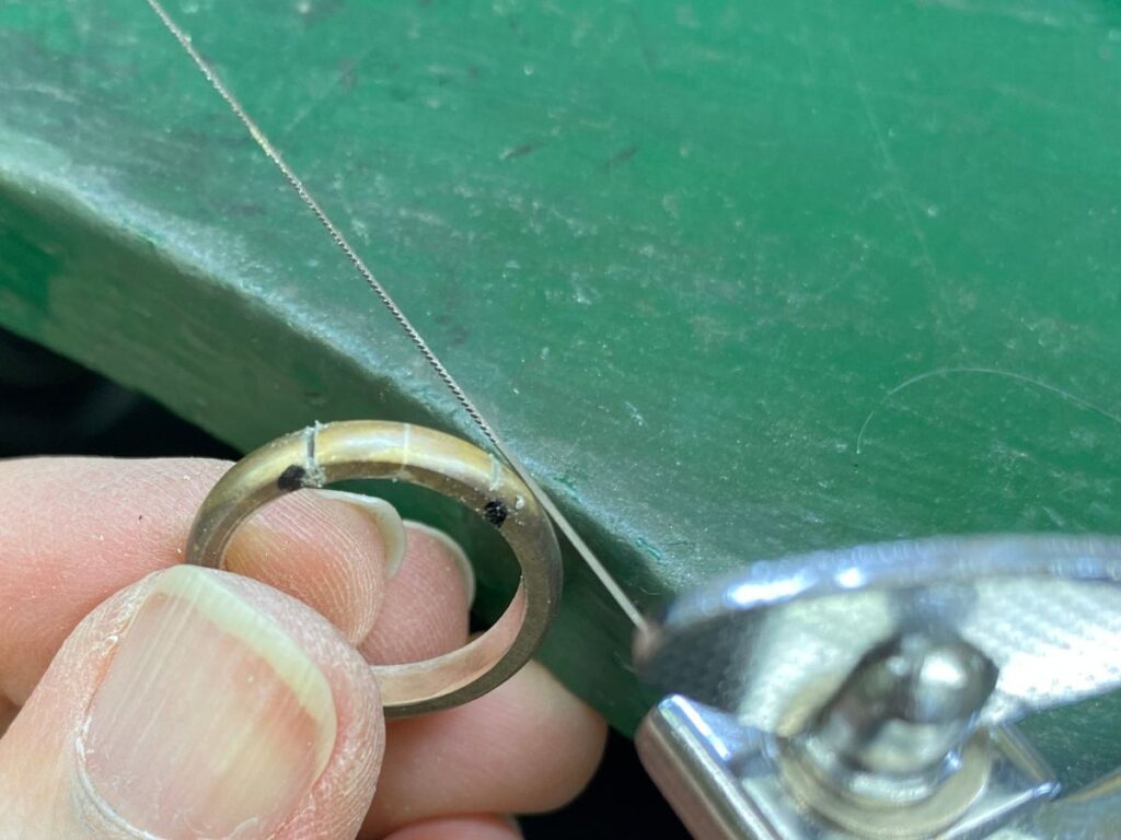 指輪の腕を糸鋸で切っているところ